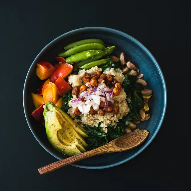 A quinoa bowl with roasted chickpeas, avocado, snap peas and peaches
